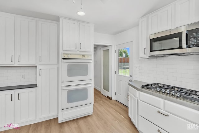 1825 Camino Primavera, Bakersfield, CA 93306 - kitchen with appliances with stainless steel finishes, white cabinets, backsplash, and light wood-type flooring