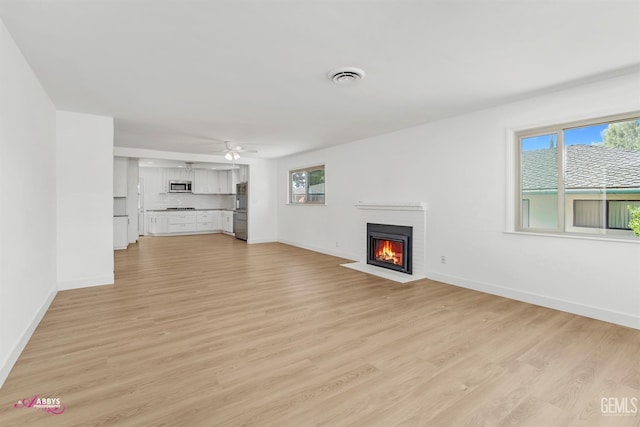 1825 Camino Primavera, Bakersfield, CA 93306 - unfurnished living room featuring a fireplace, light wood-style floors, and a ceiling fan