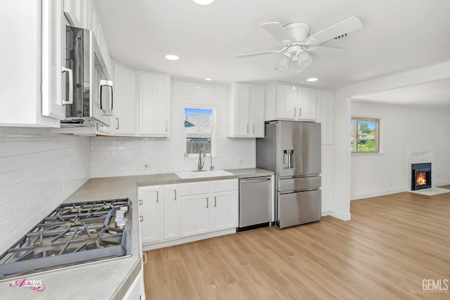 1825 Camino Primavera, Bakersfield, CA 93306 - kitchen featuring stainless steel appliances, a ceiling fan, light countertops, white cabinets, and light wood-type flooring