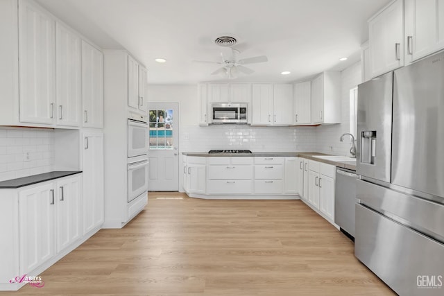 1825 Camino Primavera, Bakersfield, CA 93306 - kitchen with appliances with stainless steel finishes, a ceiling fan, backsplash, white cabinetry, and recessed lighting