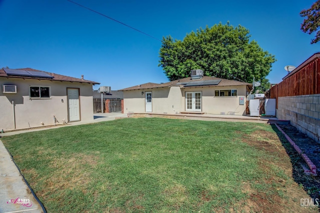 1825 Camino Primavera, Bakersfield, CA 93306 - back of house featuring french doors, roof mounted solar panels, stucco siding, and a fenced backyard