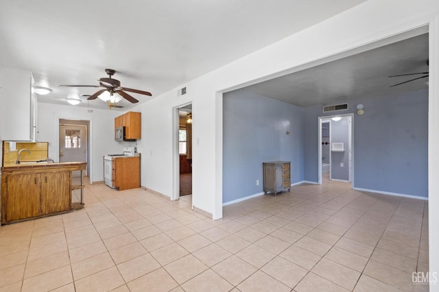 1805 Morgan Ln, Bakersfield, CA 93306 - unfurnished living room featuring a ceiling fan, light tile patterned flooring, a wood stove, and healthy amount of natural light