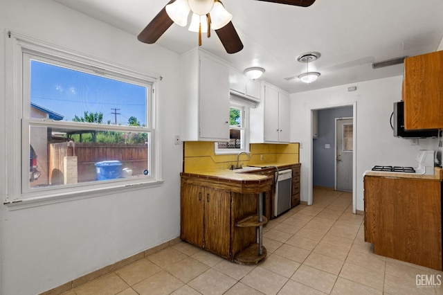 1805 Morgan Ln, Bakersfield, CA 93306 - kitchen with stainless steel dishwasher, a sink, a ceiling fan, black microwave, and white cabinets