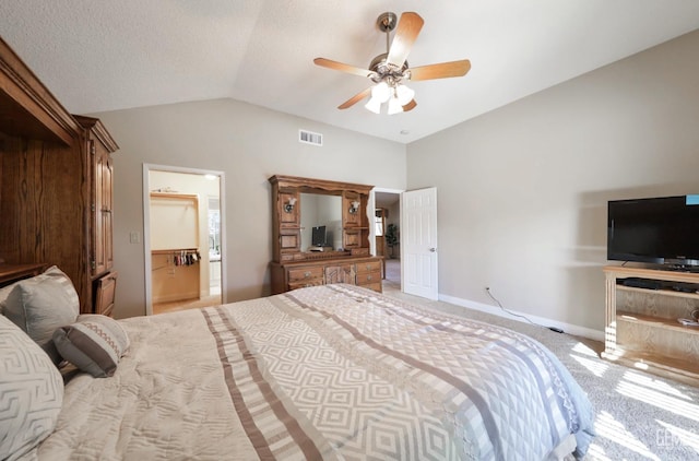 carpeted bedroom with visible vents, ceiling fan, baseboards, vaulted ceiling, and ensuite bathroom