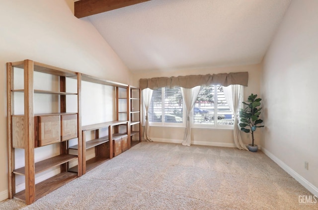 unfurnished room featuring baseboards, vaulted ceiling with beams, and carpet