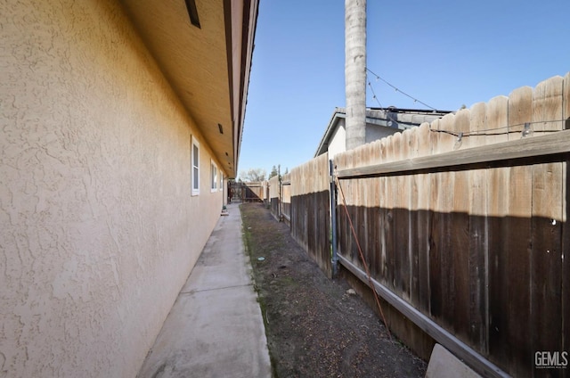 view of home's exterior featuring stucco siding and fence