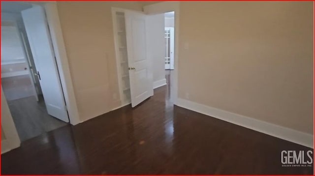 unfurnished room with baseboards and wood finished floors
