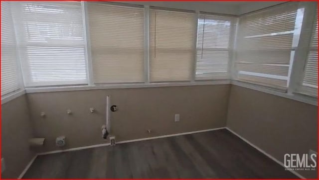 interior space with baseboards and wood finished floors