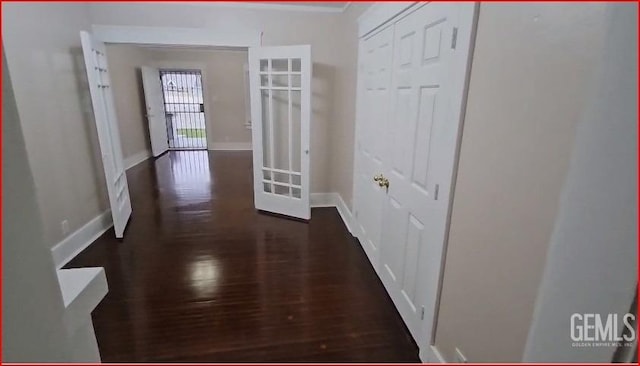 corridor featuring dark wood-style floors and baseboards