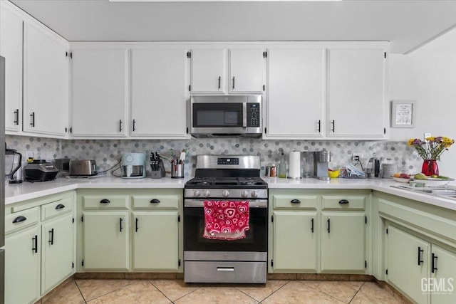 kitchen featuring light tile patterned floors, stainless steel appliances, tasteful backsplash, and light countertops