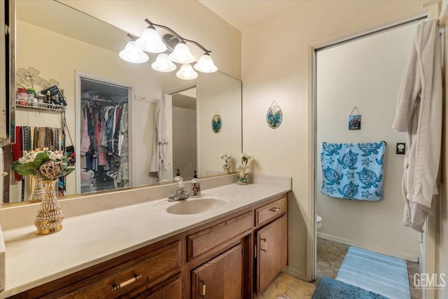 bathroom featuring toilet, an inviting chandelier, vanity, baseboards, and tile patterned floors