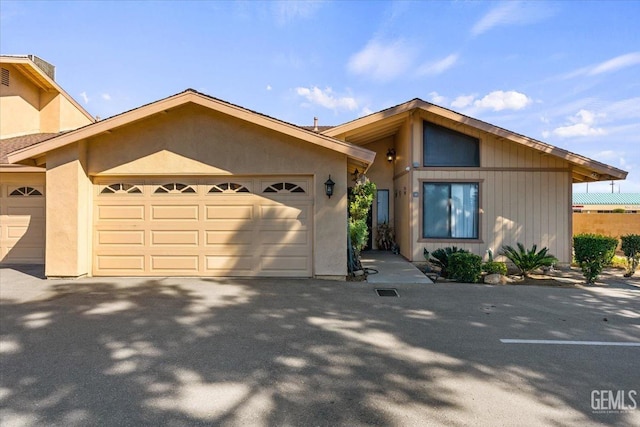 view of front of home with an attached garage, driveway, and stucco siding