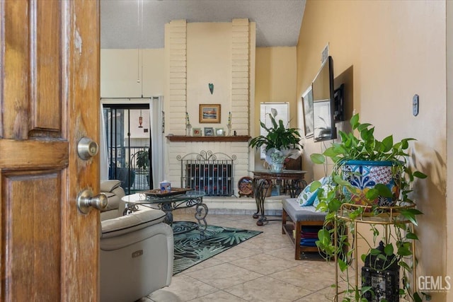 living area featuring a brick fireplace and tile patterned flooring