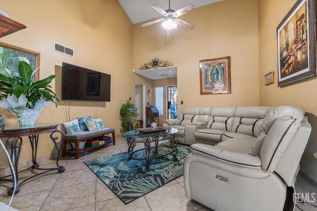 tiled living room featuring ceiling fan, a high ceiling, and visible vents