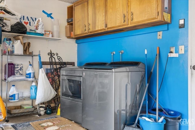 clothes washing area with cabinet space and washer and dryer