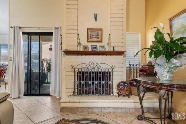 interior space with tile patterned flooring and a brick fireplace