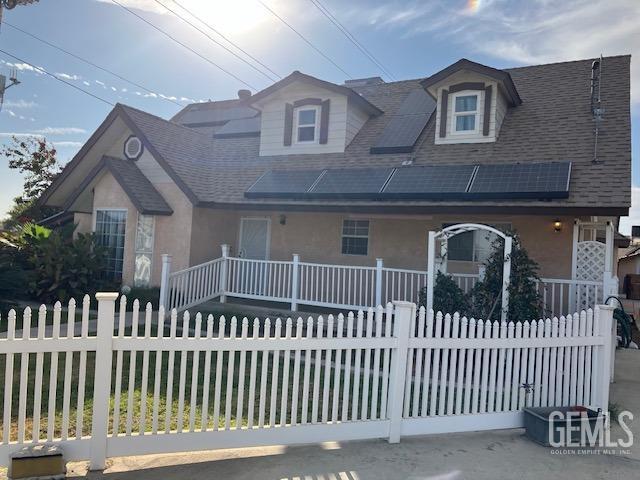 6419 Ringsdale Ct, Bakersfield, CA 93313 - view of front of property with covered porch, a fenced front yard, a shingled roof, and stucco siding