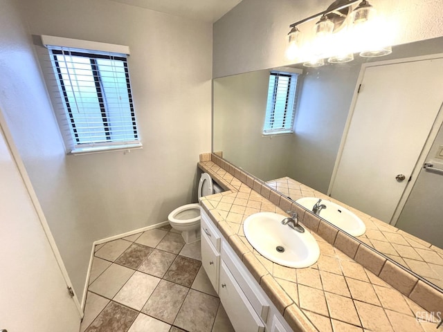 half bath featuring baseboards, toilet, tile patterned flooring, and vanity