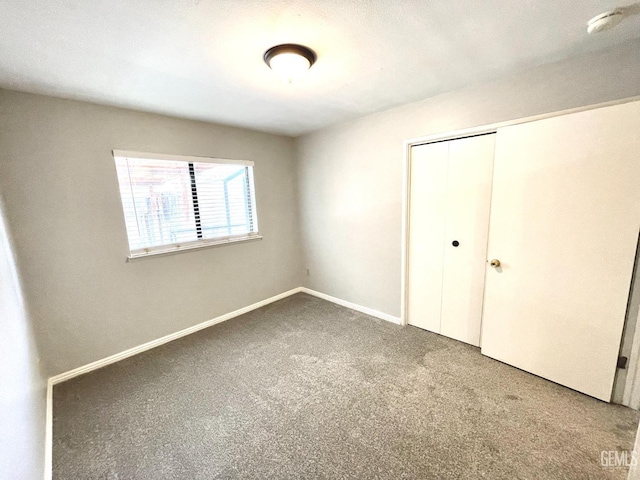 unfurnished bedroom with a closet, baseboards, and carpet