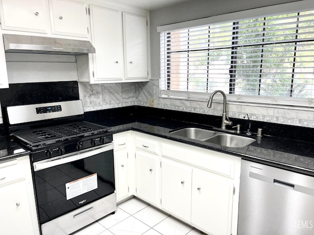 kitchen with decorative backsplash, white cabinets, stainless steel appliances, under cabinet range hood, and a sink