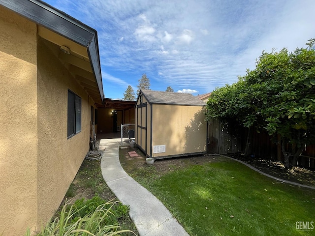view of yard featuring an outbuilding, a storage unit, and fence private yard