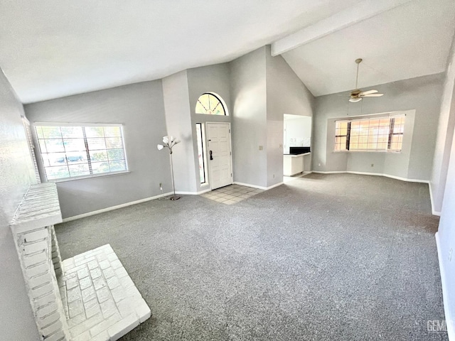 unfurnished living room featuring high vaulted ceiling, baseboards, carpet floors, beam ceiling, and a ceiling fan