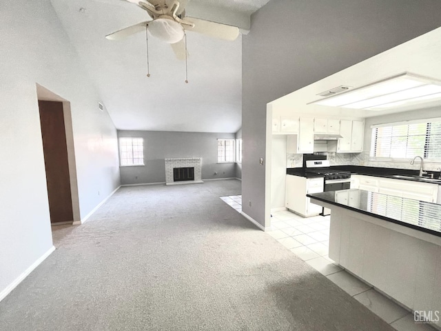kitchen featuring a sink, light carpet, gas stove, and visible vents