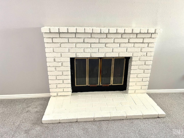 room details with a brick fireplace, carpet, and baseboards