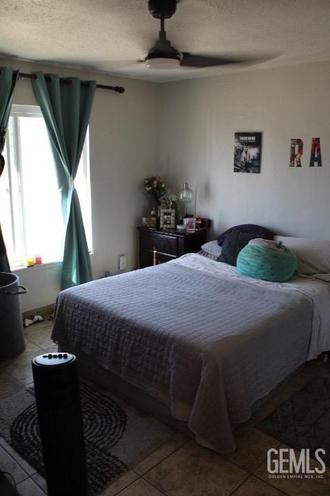 tiled bedroom featuring ceiling fan