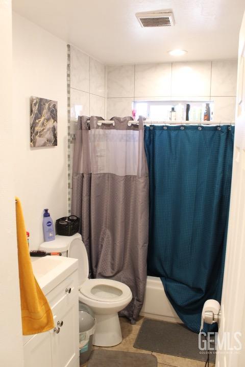 full bathroom featuring vanity, toilet, and shower / bathtub combination with curtain