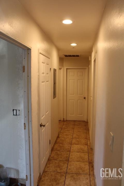 corridor featuring light tile patterned floors and electric panel