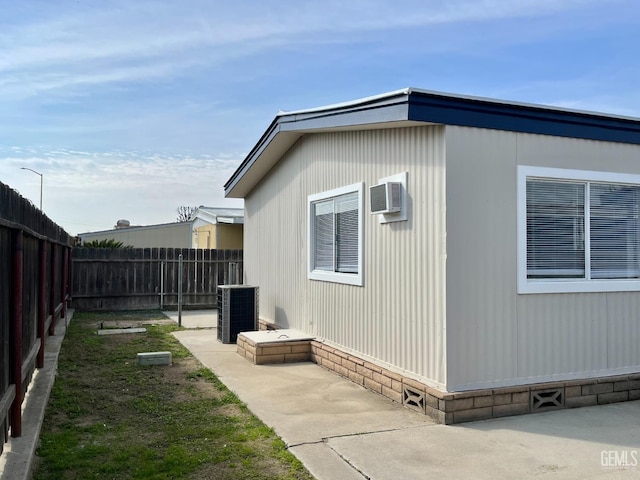 view of property exterior with a patio area, a fenced backyard, and central AC unit