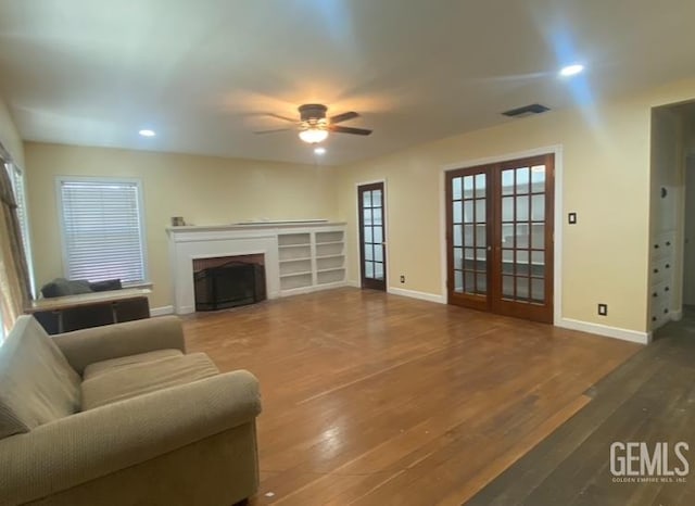 706 A St, Bakersfield, CA 93304 - living room featuring ceiling fan, french doors, baseboards, a fireplace, and wood finished floors