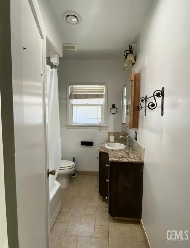 706 A St, Bakersfield, CA 93304 - full bathroom featuring vanity, toilet, shower / bathtub combination with curtain, and baseboards