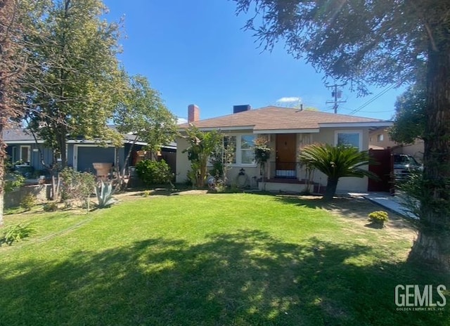 706 A St, Bakersfield, CA 93304 - view of front of property with a front lawn, a chimney, and stucco siding