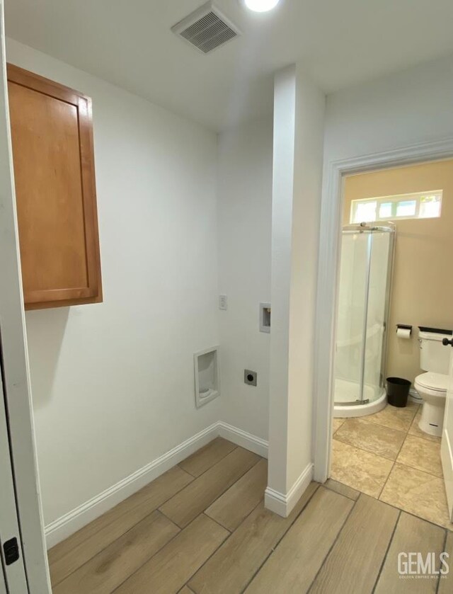 706 A St, Bakersfield, CA 93304 - washroom featuring hookup for an electric dryer, light wood-style floors, hookup for a washing machine, and baseboards