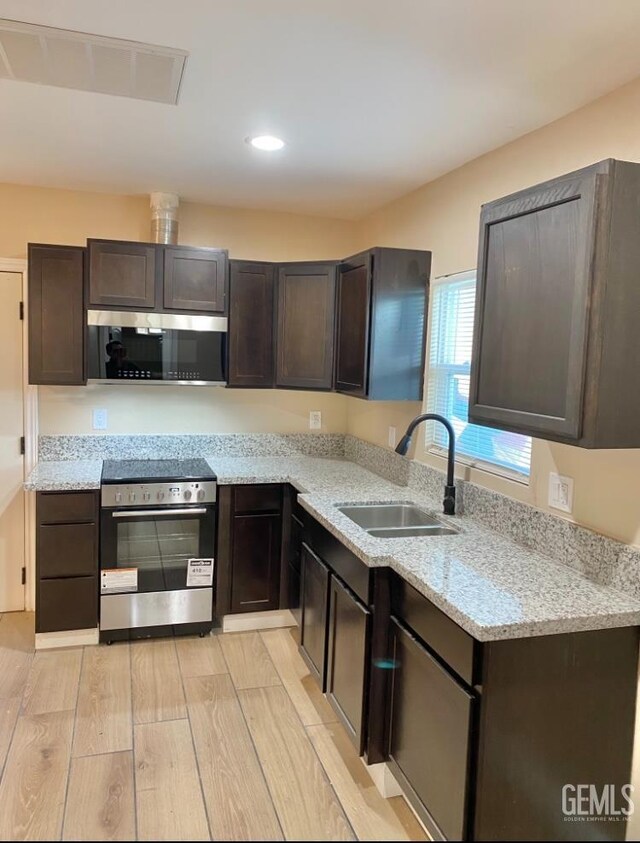 706 A St, Bakersfield, CA 93304 - kitchen with stainless steel appliances, a sink, dark brown cabinetry, and recessed lighting