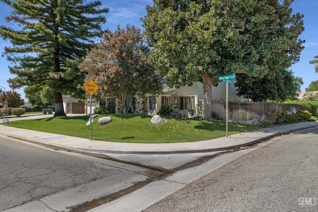 obstructed view of property featuring a front lawn