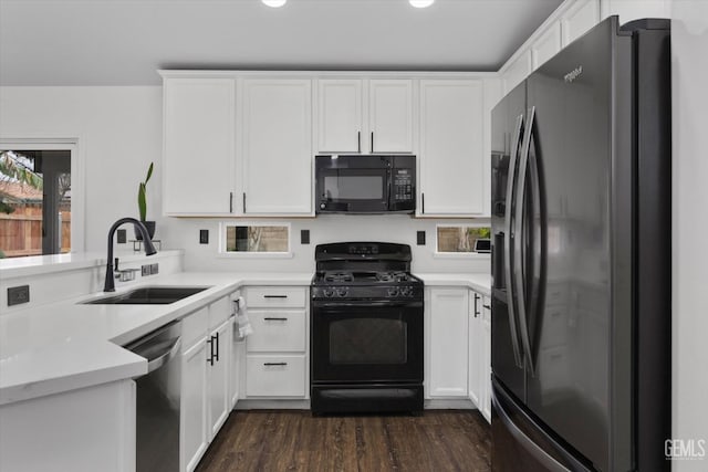 kitchen with a wealth of natural light, white cabinets, a sink, and black appliances