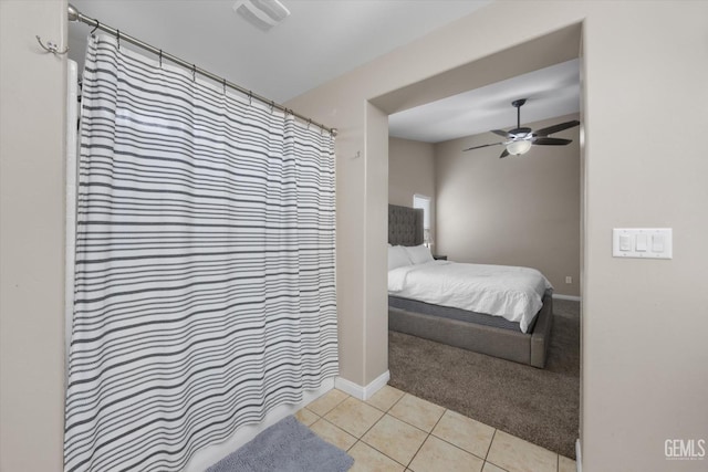 bedroom featuring ceiling fan, carpet floors, tile patterned flooring, and baseboards