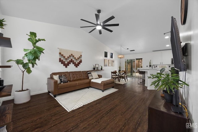 living area with vaulted ceiling, ceiling fan, wood finished floors, and baseboards