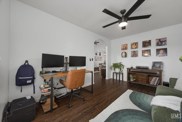 office area with a ceiling fan, arched walkways, and wood finished floors