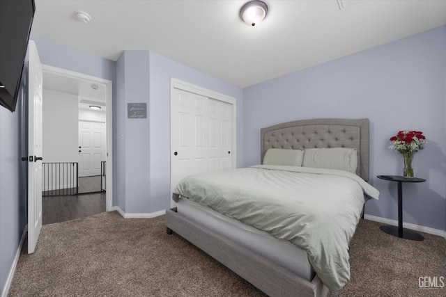 carpeted bedroom featuring baseboards and a closet