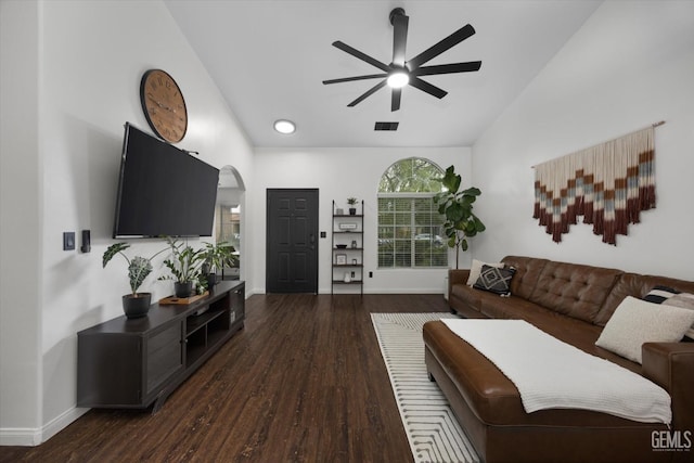 living area featuring arched walkways, ceiling fan, wood finished floors, visible vents, and vaulted ceiling