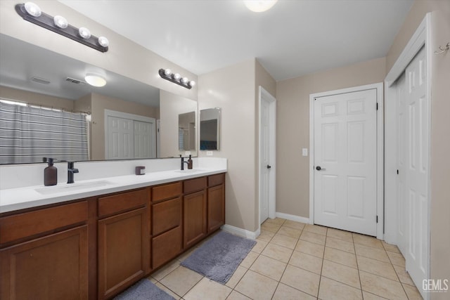 bathroom featuring double vanity, visible vents, a sink, and tile patterned floors