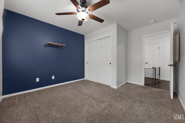 unfurnished bedroom with ceiling fan, carpet floors, a closet, and baseboards