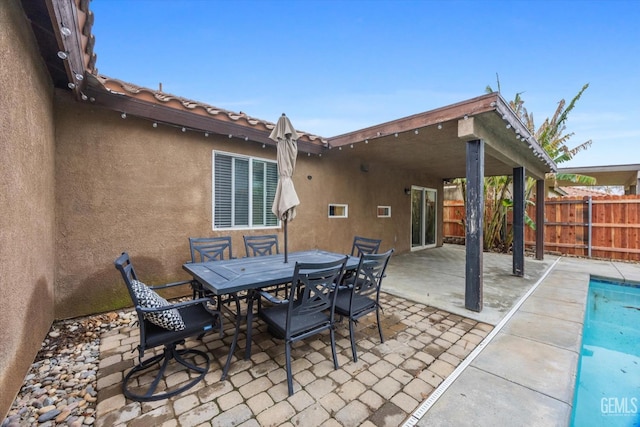 view of patio with a fenced in pool, outdoor dining area, and fence