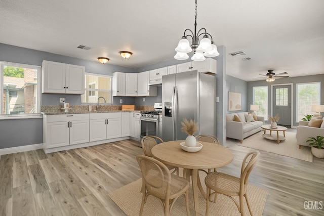 925 Yale Ave, Bakersfield, CA 93305 - kitchen with stainless steel appliances, light wood-style flooring, white cabinets, a sink, and a ceiling fan