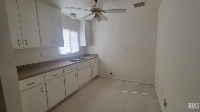 kitchen with white cabinetry, ceiling fan, and sink