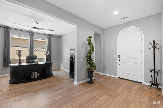 foyer entrance with light wood finished floors, baseboards, and visible vents